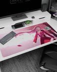 Anime-inspired 40x20 desk mat with cherry blossoms, soft pink tones, and flowing hair, accented by warm golden light