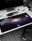 Night-sky ribbon scene on a 40x20 inches desk pad, swirling stars around a glowing center.