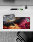 Deep navy and black starfield mouse pad 28x12 inches with magenta nebula haze and golden warmth.