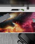 Deep navy and black 40x20 inches desk pad with magenta nebula haze and warm golden glow, calming cosmic mood.
