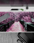 Enchanting 40x20 desk pad showcases surreal pink pathway with tranquil forest vibes for artistic workspace energy