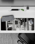 32x12 inches black-and-white manga desk mat, moody gritty-cozy slice-of-life apartment vibe.