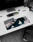 28x12 inches anime mouse pad showing a calm white figure under sakura petals with two cyan ghost flames nearby.