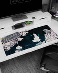36x16 inches anime desk pad showing a lone white figure under sakura, two cyan ghost flames hovering nearby.