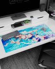 36x16 inches anime girl desk pad showing smiling girl in pastel hoodie flashing a peace sign by the sea.