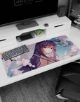 Violet-haired anime girl under an umbrella with falling cherry blossoms desk pad 36x16 inches.