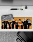 Sunset-orange gym vibe anime mouse pad, 32x12 inches, black jerseys, white numbers, green-red volleyballs.