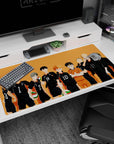 Karasuno lineup with crossed arms and spiky hair, green-red volleyball accents on desk pad 40x20 inches.
