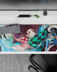 Sleek 36x16 inch desk pad featuring Tanjiro and Nezuko's intense action for anime enthusiasts