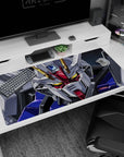Close-up Strike Gundam glaring with glowing gold eyes, cockpit tension vibe desk pad 40x20 inches.