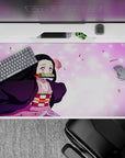 Nezuko 40x20 inch anime desk pad with pink sakura petals, vibrant eyes, and pastel tones, capturing her fierce charm.
