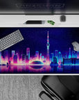 Vibrant 40x20 desk pad showcases neon skyline with stunning water reflections for fans of modern aesthetics
