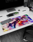 Anime desk pad 36x16 inches featuring Megumin and Komekko from KonoSuba, adorned with vibrant purples and golden flares.