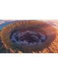 Anime desk pad 40x20 inches with wide sky over giant crater, golden cliffs, wildflowers, and spiral clouds.