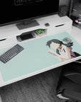 Cute anime schoolgirl with dark twin ponytails, hands clasped wishing luck on a 40x20 inches desk pad.