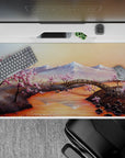 40x20 inches desk pad with cherry blossom landscape, showcasing snow-capped mountains, a tranquil river, and delicate pink blossoms for natural beauty.