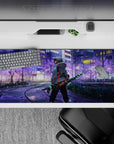 Tanjiro from Demon Slayer walks in neon-lit Tokyo with sakura tones and checkered blade on a 36x16 inch anime desk pad.