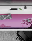 36x16 inches desk pad with Blossom Horizon, featuring a tranquil cherry blossom tree, serene pink sunset, and distant mountains for a calming vibe.