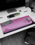 Artistic 36x16 inches desk pad featuring Blossom Horizon, capturing the beauty of a cherry blossom tree with a peaceful pink sunset and mountains.