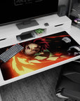 Tanjiro from Demon Slayer with fiery blade on 40x20 inch anime desk pad, vivid reds and golds against a black background.