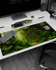 Serene 40x20 anime desk mat featuring moss-covered trees, ferns, vines, and soft light filtering through mist for a peaceful rainforest vibe