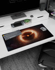 Tiny burning star in amber clouds mouse pad 32x16 inches, set against a deep black space background.