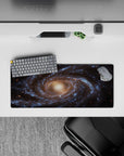 Large 28x12 inch mouse pad featuring a detailed spiral galaxy design with blue and golden cosmic tones.