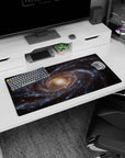Large 32x16 inch desk mouse pad featuring a calming spiral galaxy design with smoky blues and golden tones.