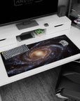Spiral galaxy desk pad 36x16 inches with swirling blue, gold, and black cosmic design for a calming workspace.
