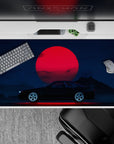 40x20 inches desk pad with the Midnight Skyline Eclipse, showcasing a black car and a striking red moon under a deep blue night sky.