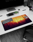 Modern 32x16 inches mouse pad showcasing a sunset forest with warm oranges and golds, perfect for creativity and adventure.