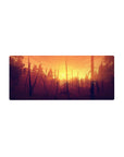 Mouse pad featuring a sunset forest, 28x12 inches, with warm oranges and golds, perfect for inspiring creativity and adventure.