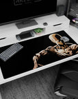 Saitama seated in quiet focus anime desk pad 40x20 inches, one hand on shoulder, blank gaze.