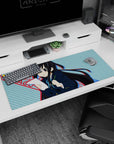 36x16 inches K-ON! Azusa Nakano desk pad, holding paper and pencil mid-cram with a shy blush.