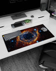 Large cosmic eye nebula pattern mouse pad with inky galaxy backdrop, 32x16 inches.