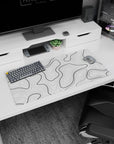 Modern 32x16 inches mouse pad featuring black and white contour design, with bold black lines and a white background, adding depth and movement.