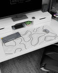 Artistic 36x16 inches desk pad featuring black and white contour design, blending depth and movement with bold lines on a clean white background.