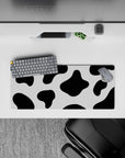Playful 28x12 mouse pad with black and white cow print spots, perfect for expressing creativity and fun in your desk setup