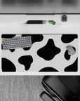 Playful 32x16 mouse pad featuring black and white cow print spots, perfect for expressing personality and creativity in your workspace