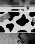Playful 40x20 desk pad featuring cow print-inspired design with bold black and white spots for a fun, whimsical desk aesthetic