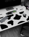 Fun 40x20 anime desk mat with bold black and white cow print spots, perfect for expressing creativity and personality in your workspace