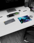 Iconic 14x10 desk mat celebrates Cosmic Cascade with deep blues, purples, emerald swirls, and galactic elegance