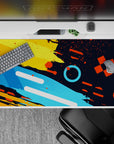 Dynamic 40x20 desk pad showcases geometric shapes and energetic splashes for an inspiring workspace vibe