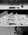 Eerie stillness 40x20 desk pad with kneeling astronauts and an ominous figure, capturing a chilling cosmic horror atmosphere in stark manga style
