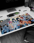 Sharp-eyed girl in white uniform centered on anime desk pad 40x20 inches, friends with skewers and bowls.