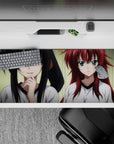 Desk pad featuring Rias and Akeno from High School DxD, 36x16 inches; playful vs. serious vibes in soft lighting.