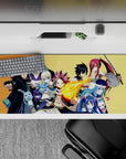 Gold background anime desk pad 36x16 inches with fiery reds, cool blues, and steel tones for hype gaming.
