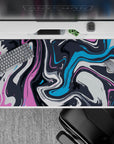 Vibrant 40x20 desk pad featuring dynamic swirls of pink, blue, and charcoal for a burst of artistic energy and color