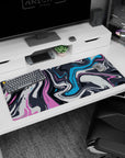 Fluid 36x16 anime desk mat with dynamic swirls in pink, blue, and charcoal, adding a burst of creativity and color to your desk