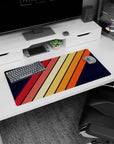 Modern 32x16 inches mouse pad showcasing bold diagonal stripes in warm orange, red, and yellow hues, set against a classic navy background.